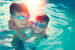 © sakkmesterke - Happy little kids have fun in swimming pool graded in sunset