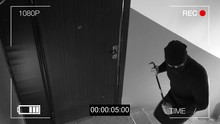 See CCTV As A Burglar Breaking In Through The Door With A Crowbar.