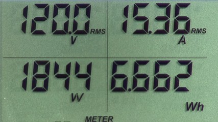 LCD display of digital power meter showing voltage, current, power and energy usage