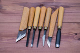 Fototapeta Tęcza - Tool kit for woodcarving. Knives for carving on wooden background