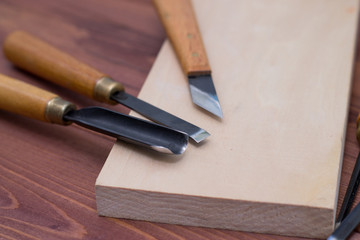 Tool kit for woodcarving. Knives for carving on wooden background