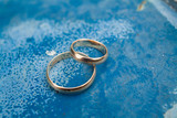 Fototapeta Konie - couple golden rings on blue metal surface
