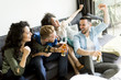 © BGStock72 - Friends watching TV , drinking cider and having fun in the room