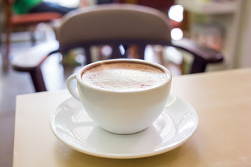 Hot Cappuccino Coffee cup on the wood table in shop