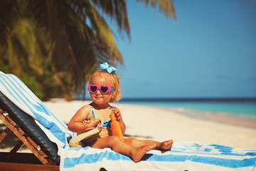 Wall Mural - sun protection - little girl with sunblock cream on beach