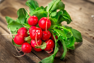 Wall Mural - Bunch of fresh red radishes on a wooden table