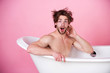 © Volodymyr - man with muscular body sitting in white bathtub