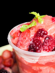 Wall Mural - Closeup top of Mixed berry fruit smoothies in plastic cup. Refreshment healthy drink. On black isolate background.