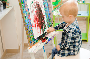 a child draws a picture paints on art lesson