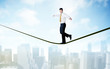© ra2 studio - Salesman walking on rope above the city