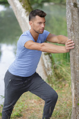 Wall Mural - young man stretching his leg after a heavy workout