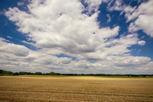 Cloudy Blue Sky Over The Field With Harvested Grain