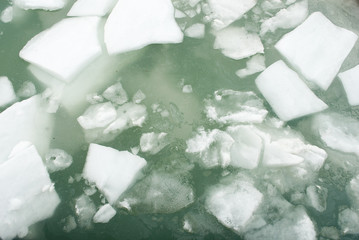 Graphic background: large pieces of white ice during spring thaw, in a lake of a mountain dam, water of a light green color, alps, switzerland