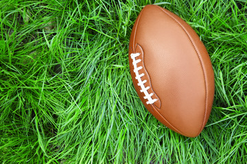 Canvas Print - Ball for American football on green grass