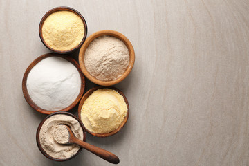 Poster - Wooden bowls with different types of flour on table