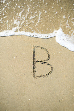 B Letter drawn on the sand beach