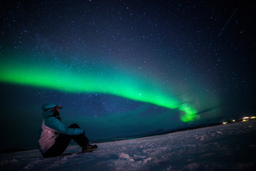 Wall Mural - Girl watching the Northern Lights. Abisko Sweden