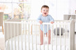 © Africa Studio - Cute little baby standing in crib at home