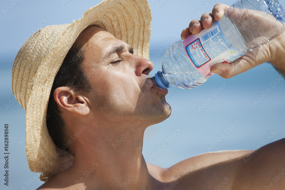 Homme La Plage Qui Boit De L eau Min rale Avec Une Bouteille Stock homme-la-plage-qui-boit-de-l-eau-min-rale-avec-une-bouteille-stock