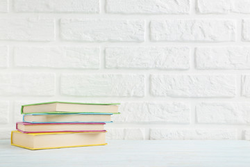 Colorful books on a brick wall background