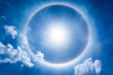 The Storng Sun Halo At Noon Time On The Blue Sky And Cumulus Clouds