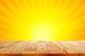 Wood table top on yellow and orange radiate (sunburst) background