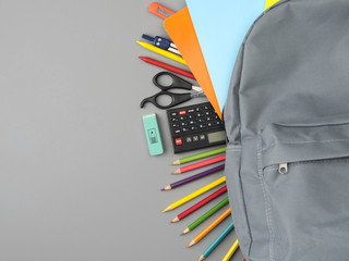 Top view of school supplies on grey background