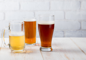 Wall Mural - Beer glasses with various beer on wood table against white brick wall