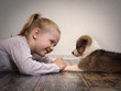 © kozorog - happy child and a small puppy lying on the floor facing each other. Girl meets dog