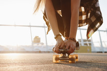 Hipster girl legs and hands with rings on a skate board