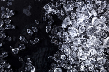 Wall Mural - pieces of crushed ice cubes on black background. copy space, top view