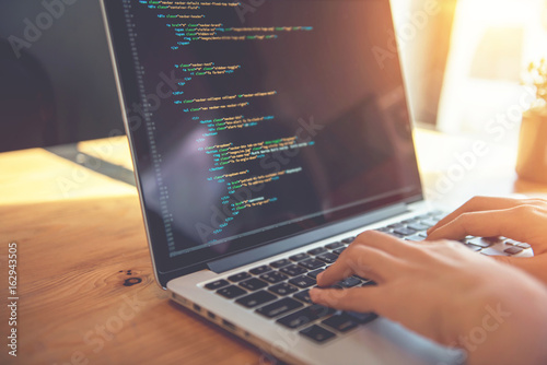 Fotografía Closeup coding on screen, Woman hands coding html and programming on screen laptop, development web, developer