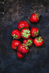 Wall Mural - a bunch of fresh juicy strawberries on a dark old background, top view