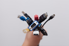 Hand Holding A Bunch Of Computer Cables With Different Connectors