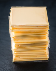 Wall Mural - Sliced Cheese on a slate slab (selective focus)