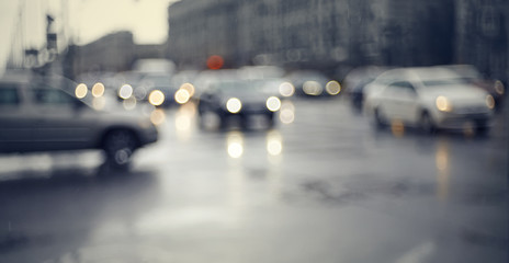 Blurry unfocused background with the city road with cars in twilight