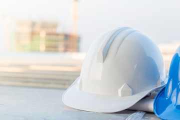 Wall Mural - The safety helmet and the blueprint at construction site with crane background