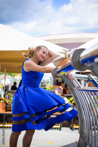 Fotografía Blond hair curly woman plus size european appearance in blue flying retro dress