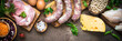 Meat cheese beans and vegetables on dark stone table. Meat assortment. Long banner format.
