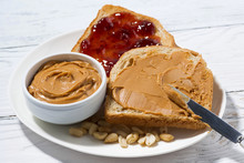 Toast With Peanut Butter And Jam For Breakfast On White Table