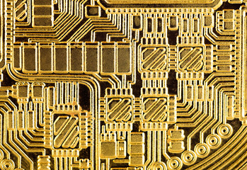 Abstract background : Golden electronic circuit, macro photo. Image taken from gold plated coin stamped in form of electronic circuit as normally seen in PCB (Printed Circuit Board).