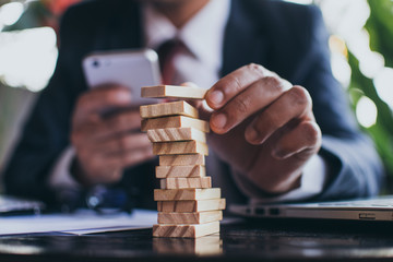 Business man building domino tower 