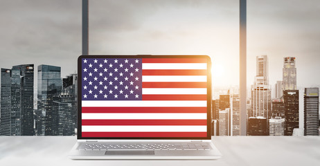 Independence Day on office laptop screen with panoramic sunset view of modern downtown skyscrapers at business district