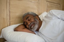 Senior Man Sleeping On Bed In The Bedroom