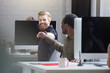© Drobot Dean - Smiling bearded man giving a fist bump to a male colleague