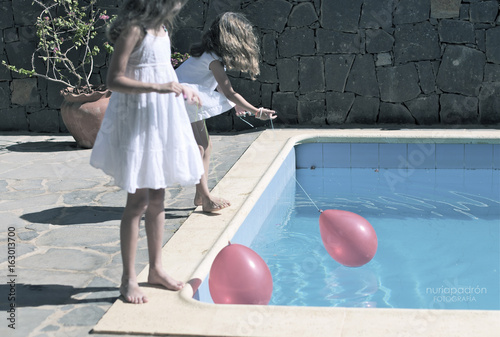 trajes blancos jugando con globos rojos