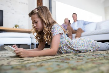 Wall Mural - Daughter using digital tablet in living room 