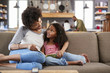 © Monkey Business - Mother And Daughter Sit On Sofa In Lounge Reading Book Together