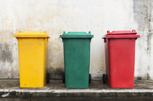 Three Colorful Bins With Brick Wall Background