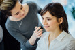 © Iryna - Backstage scene: Professional Make-up artist doing make up for young beautiful brunette woman.